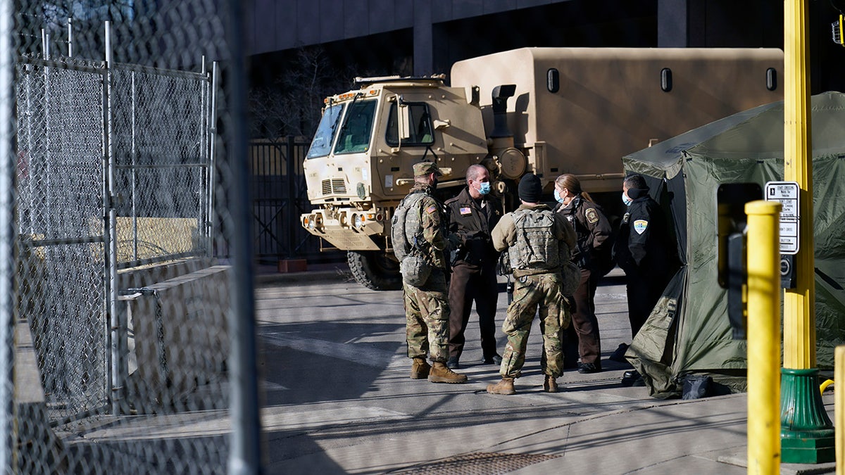 Deputies and National Guard soldiers converse, Tuesday, March 9, 2021, in Minneapolis where the trial for former Minneapolis police officer Derek Chauvin continues with jury selection. Chauvin is charged with murder in the death of George Floyd during an arrest last may in Minneapolis. AP Photo/Jim Mone)