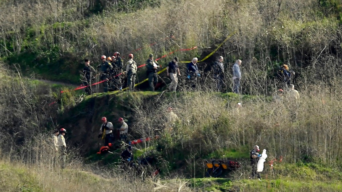 In this Jan. 27, 2020, file photo, investigators work the scene of a helicopter crash that killed former NBA basketball player Kobe Bryant in Calabasas, Calif.  (AP Photo/Mark J. Terrill, File)