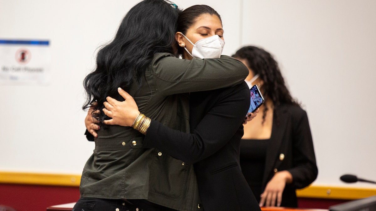 Des Moines Register reporter Andrea Sahouri, facing, hugs her mother, Muna Tareh-Sahouri, after being found not guilty at the conclusion of her trial at the Drake University Legal Clinic, Wednesday, March 10, 2021, in Des Moines, Iowa. An Iowa jury acquitted Andrea Sahouri, who was pepper-sprayed and arrested by police in the summer of 2020 while covering a protest in a case that critics have derided as an attack on press freedom and an abuse of prosecutorial discretion. (Kelsey Kremer/The Des Moines Register via AP, Pool)