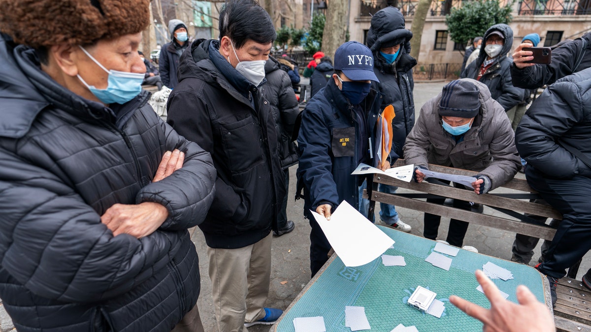 FILE - In this March 17, 2021, file photo, Detective Suk H Too, second from right, with the New York Police Department Community Affairs Rapid Response Unit hands out fliers with information on how to report hate crimes to residents while on a community outreach patrol in the Chinatown neighborhood of New York. Asian Americans, already worn down by a year of racist attacks fueled by the pandemic, are reeling but trying to find a path forward in the wake of the horrific shootings at three Atlanta-area massage businesses that left eight people dead, most of them Asian women. (AP Photo/Mary Altaffer, File)