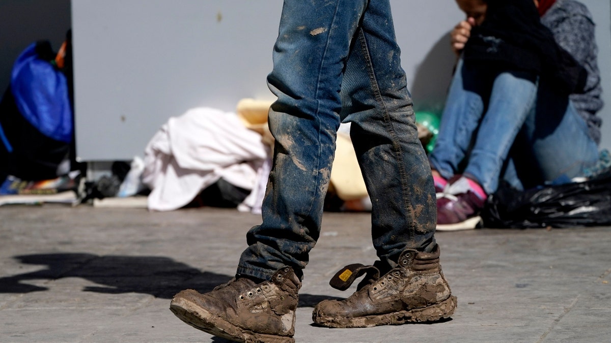 A migrant's muddy shoes are seen without laces as he walks off the customs checkpoint in Reynosa, Mexico, after being deported by U.S. Customs and Border Protection agents. (AP Photo/Julio Cortez)