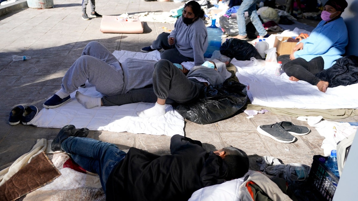 Migrants, who were caught trying to sneak into the U.S. and deported, eat near the McAllen-Hidalgo International Bridge point of entry into the U.S. (AP Photo/Julio Cortez)