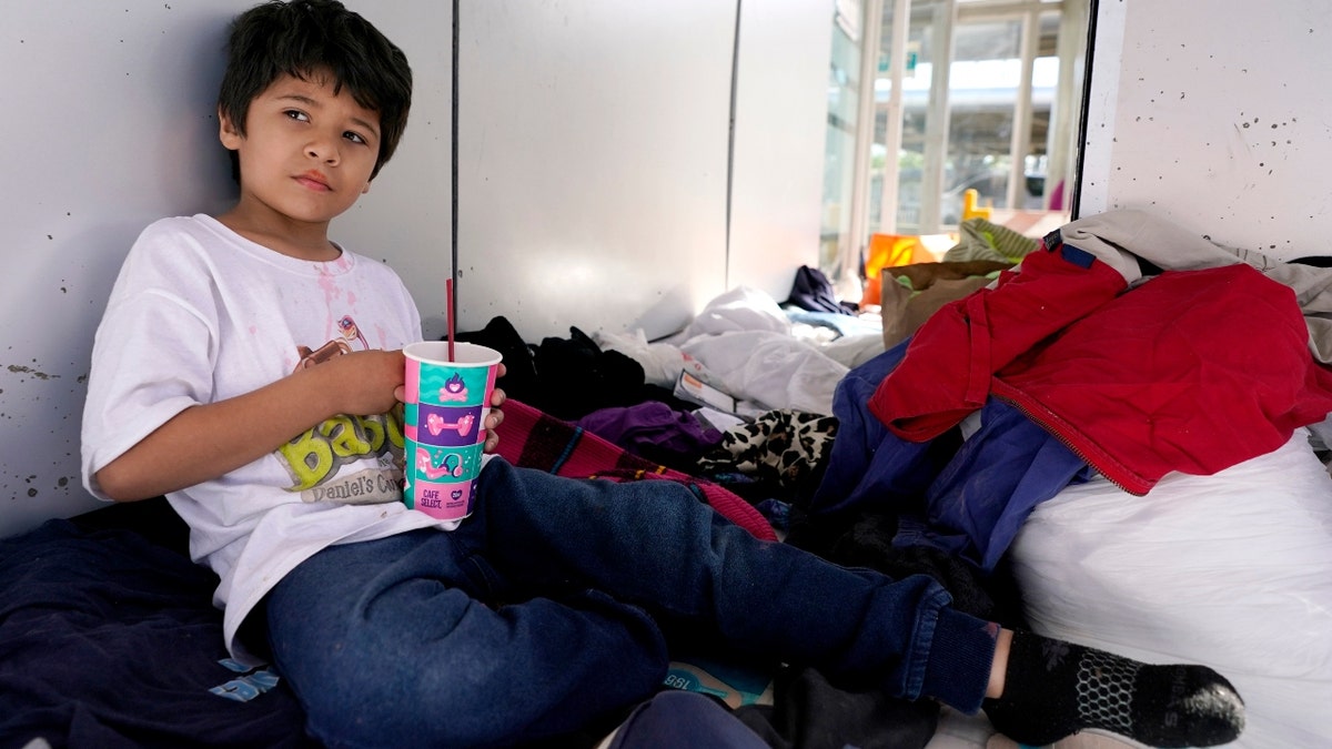 Miguel David Fajardo, 8, a migrant from Honduras, rests at a plaza near the McAllen-Hidalgo International Bridge point of entry into the U.S., after he, his 13-year-old brother and their mother were caught trying to sneak into the U.S. and deported. (AP Photo/Julio Cortez)