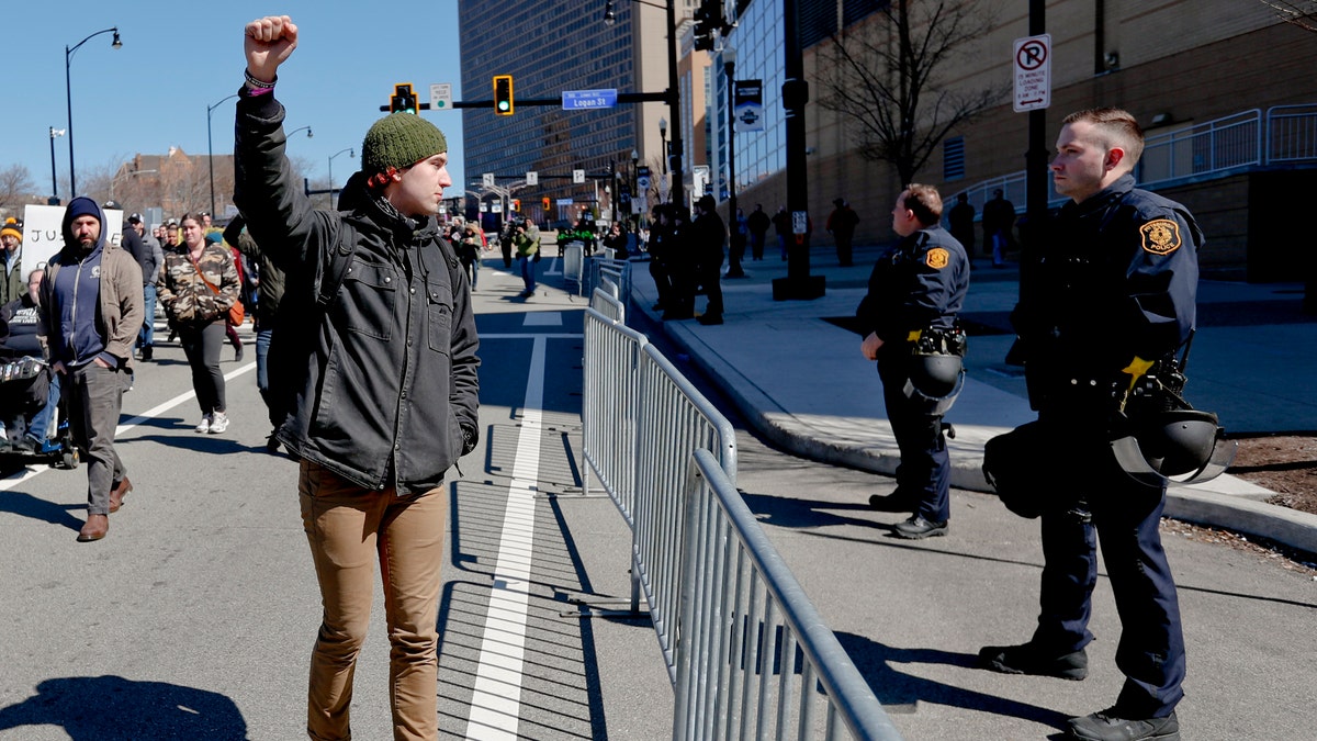 In this March 23, 2019, file photo, a marcher holds up his fist while staring at police lined up in front of PPG Paints Arena in Pittsburgh during a protest after a former suburban police officer was acquitted of a homicide charge in the on-duty shooting death of Antwon Rose II in East Pittsburgh. (AP Photo/Keith Srakocic)