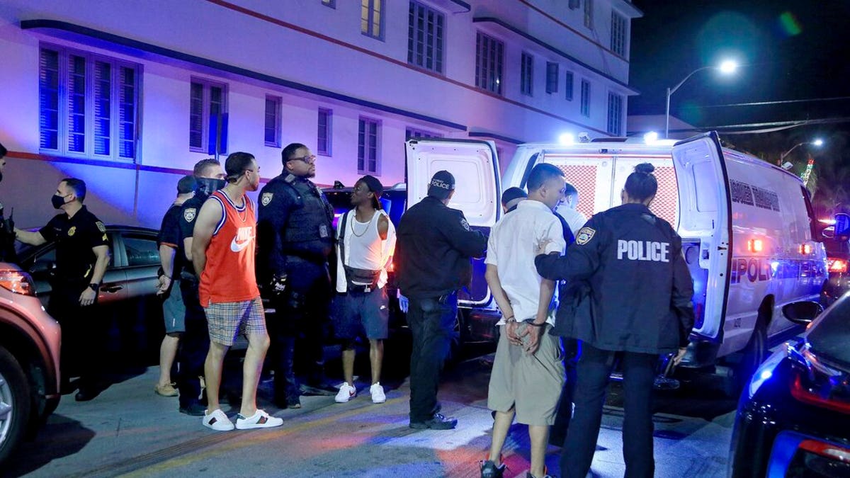 City of Miami Beach Police officers arrest several males on Ocean Drive and 10th Street as spring break has officially begun Saturday, Feb. 20, 2021 in Miami Beach, Fla. 