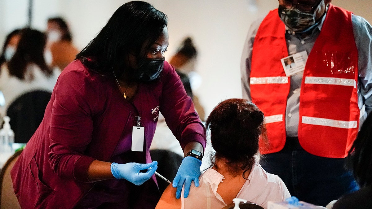 Health worker administers a dose of a Pfizer COVID-19 vaccine during a vaccination clinic at the Grand Yesha Ballroom in Philadelphia.  (AP Photo/Matt Rourke, File)