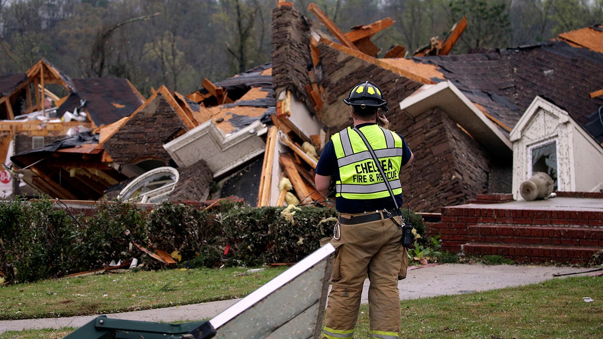 A firefighter surveys damage to a house where the family was trapped, but were able to get out after a tornado touched down south of Birmingham, Ala., March 25, 2021. (Associated Press)