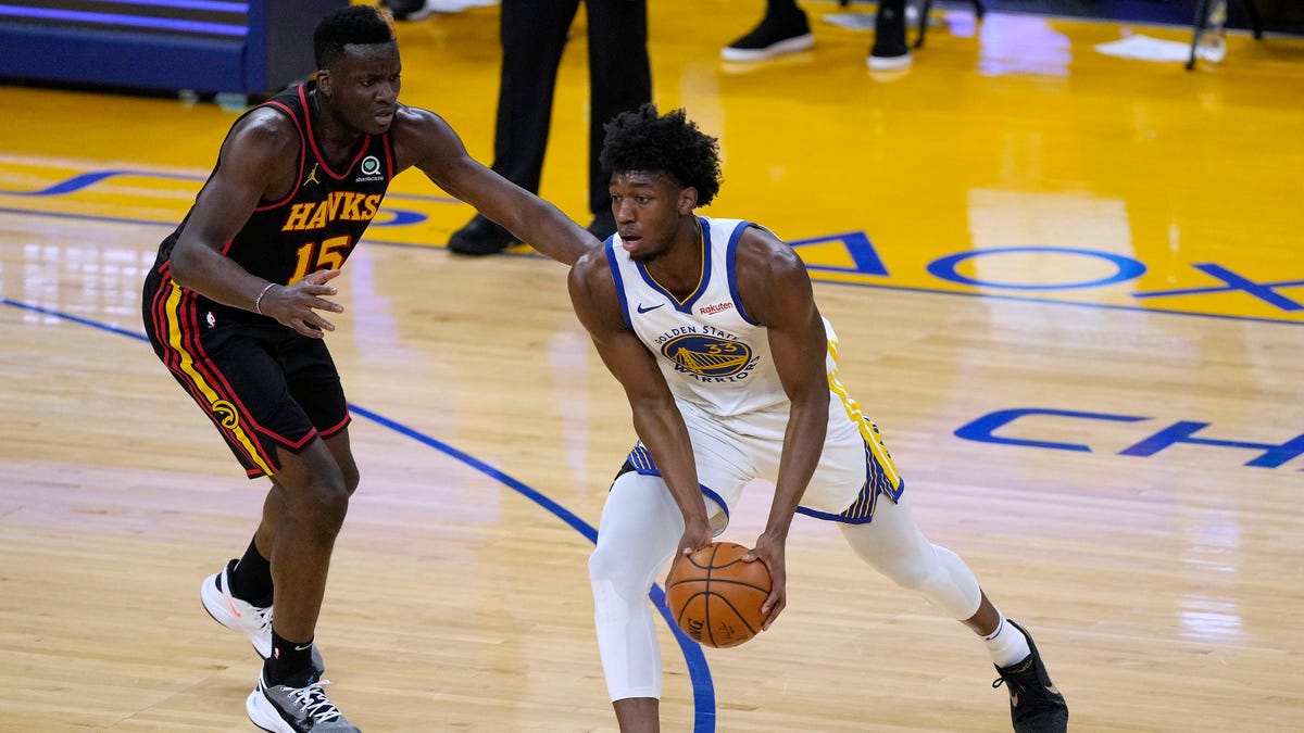 Golden State Warriors center James Wiseman (33) moves the ball past Atlanta Hawks center Clint Capela (15) during the first half of an NBA basketball game in San Francisco, Friday, March 26, 2021. (AP Photo/Tony Avelar)