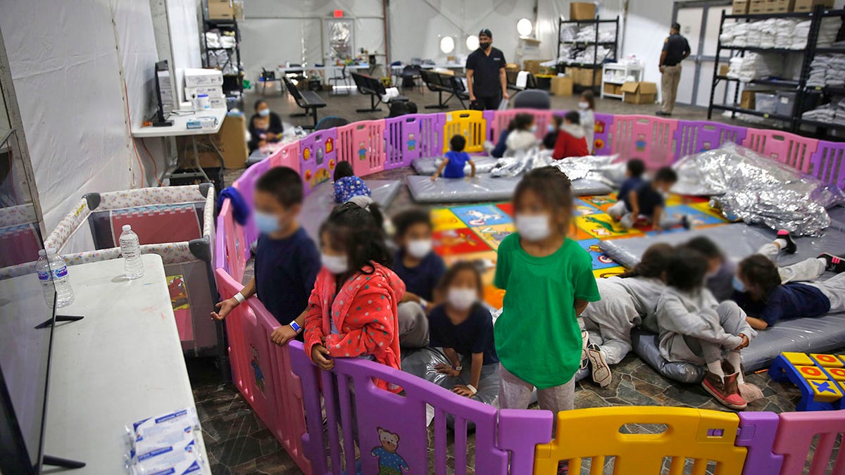 Young unaccompanied migrants, from ages 3 to 9, watch television inside a playpen at the U.S. Customs and Border Protection facility. (AP Photo/Dario Lopez-Mills, Pool)