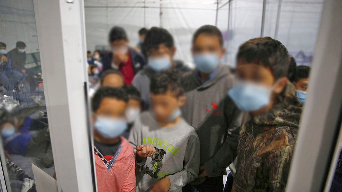 Young children look out from inside a pod at the Donna Department of Homeland Security holding facility. (AP Photo/Dario Lopez-Mills, Pool)