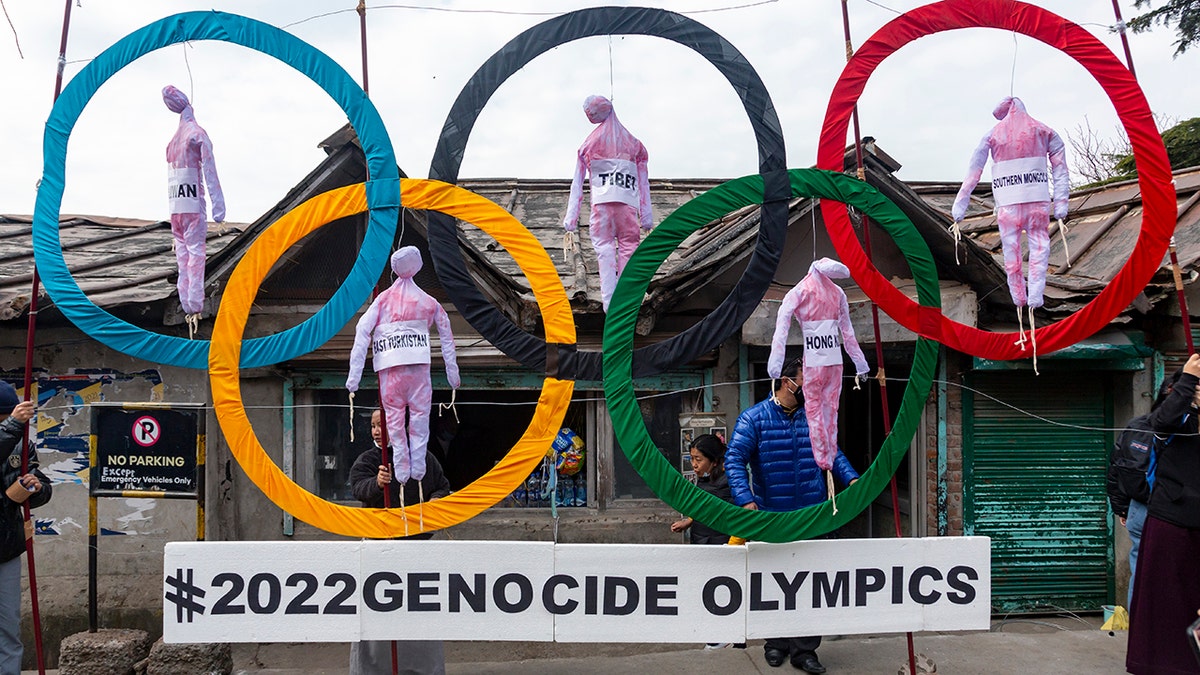 In this Feb. 3, 2021, file photo, exiled Tibetans use the Olympic rings as a prop as they hold a street protest against the holding of 2022 Winter Olympics in Beijing in Dharmsala, India. Some kind of boycott is almost sure to affect next year’s Beijing Winter Olympics. (AP Photo/Ashwini Bhatia, File)