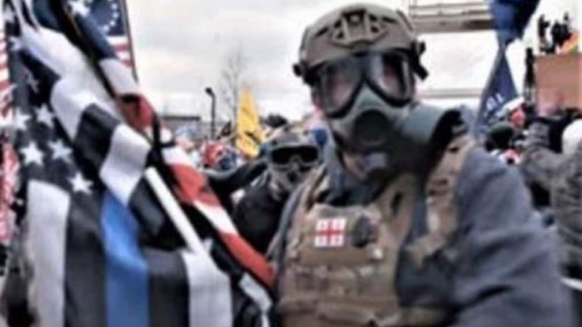 A man identified by the FBI as Jeffrey McKellop is seen holding a "thin blue line" flag during the Capitol riot. McKellop has been charged with assaulting police officers, including throwing a flagpole at one.