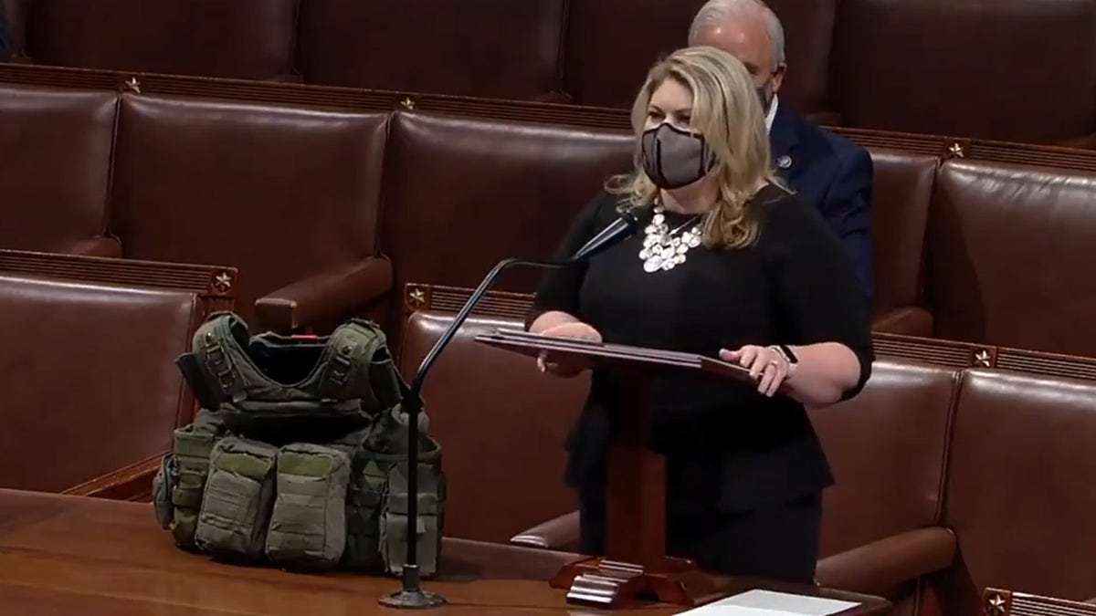 Rep. Kat Cammack, R-Fla., speaks on the House floor with her husband's SWAT vest.