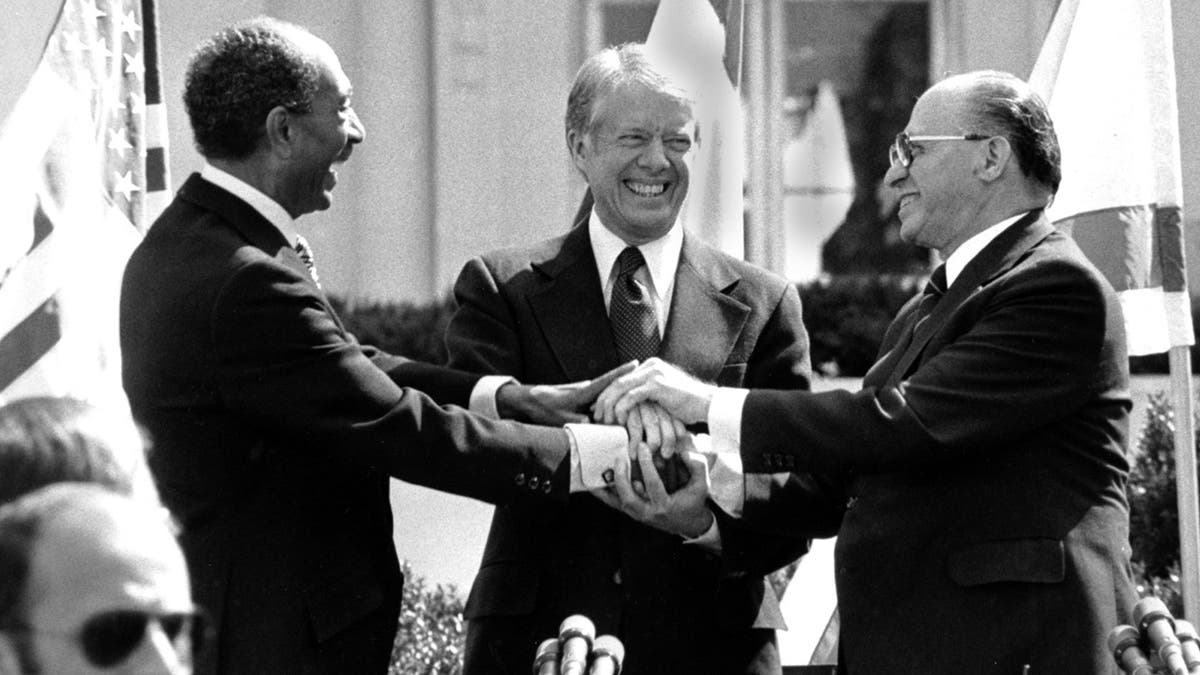 Egyptian President Anwar Sadat, left, U.S. President Jimmy Carter, center, and Israeli Prime Minister Menachem Begin clasp hands on the north lawn of the White House after signing the peace treaty between Egypt and Israel on March 26, 1979. (AP Photo/ Bob Daugherty)