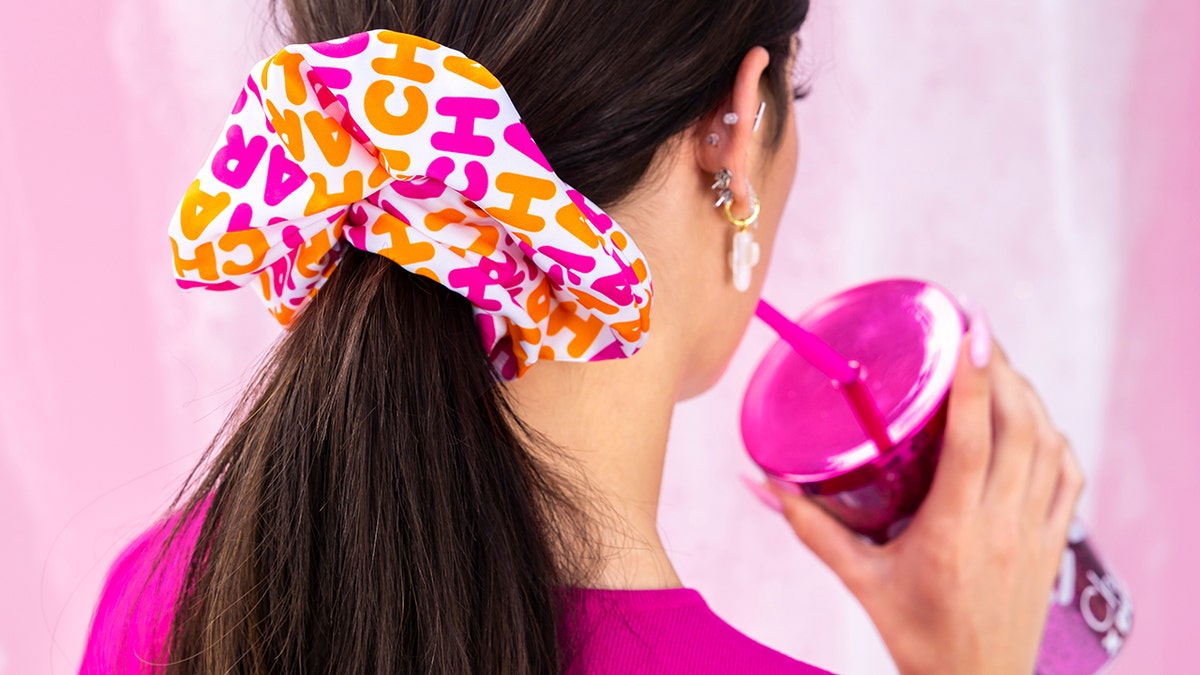 The Charli x Dunkin' line includes a onesie, a set of scrunchies, a tumbler, shoelaces, a keychain and an iPhone case.