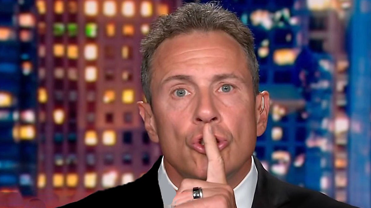 Chris Cuomo holding his finger to his lips in a hushing motion