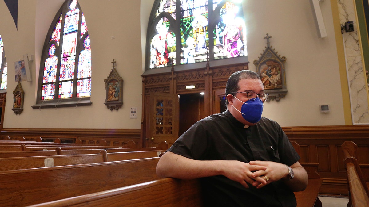 The Rev. Manuel Rodriguez sits in the pews of his church, Our Lady of Sorrows, on Friday, March 5, 2021, in the Queens borough of New York. (AP Photo/Jessie Wardarski)
