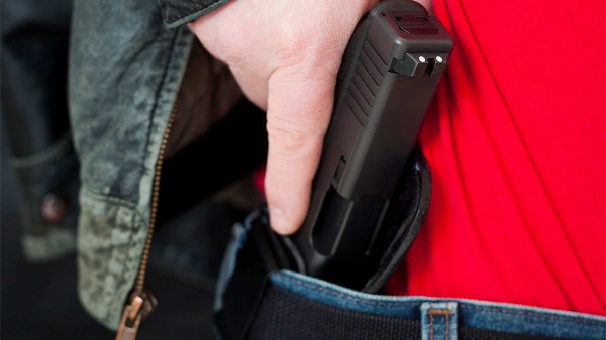 Man with hand on gun holstered at hipcealed carry