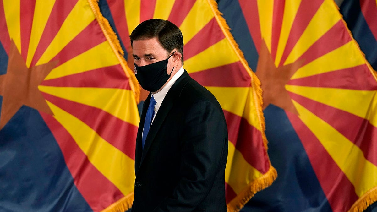 FILE - In this Dec. 2, 2020, file photo, Arizona Republican Gov. Doug Ducey arrives for a news conference to talk about the latest Arizona COVID-19 information in Phoenix. Ducey is prohibiting government mask mandates and allowing bars and nightclubs shuttered for months to open their doors without restrictions. Ducey's move Thursday, March 25, 2021, leaves in place few of the restrictions he implemented to curb the spread of the coronavirus. (AP Photo/Ross D. Franklin, Pool, File)