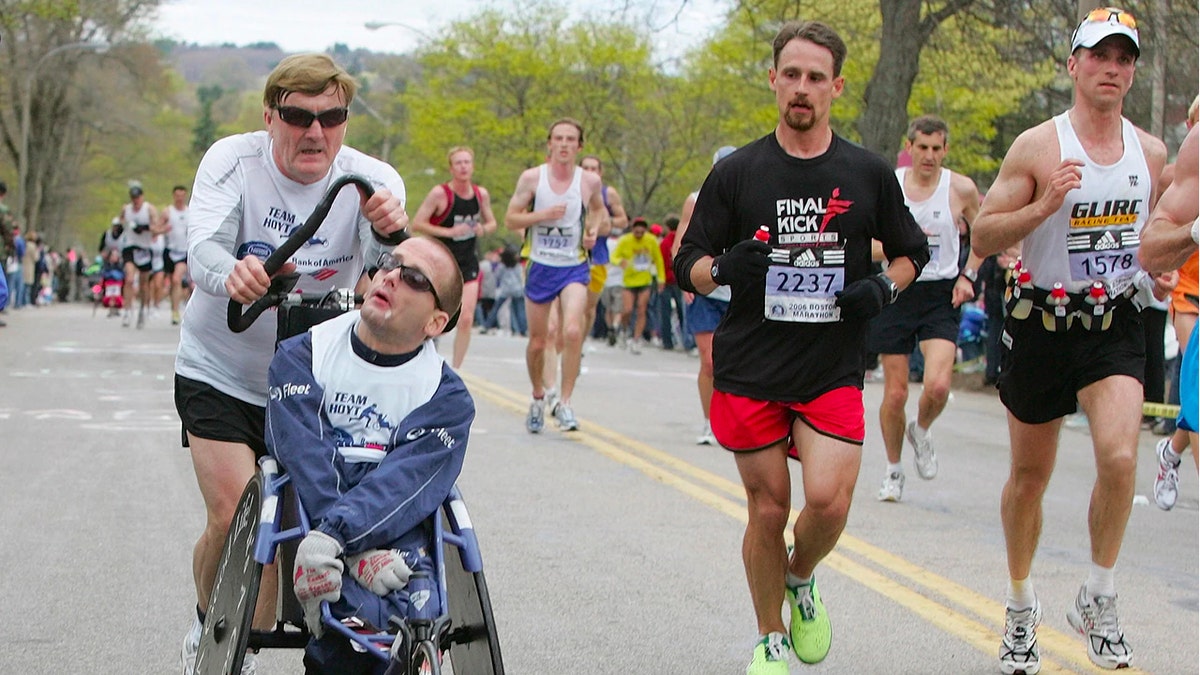 FILE - In this April 17, 2006, file photo, Dick Hoyt pushes his son Rick through Newton, Mass., during their 25th Boston Marathon together. (AP Photo/Adam Hunger, File)