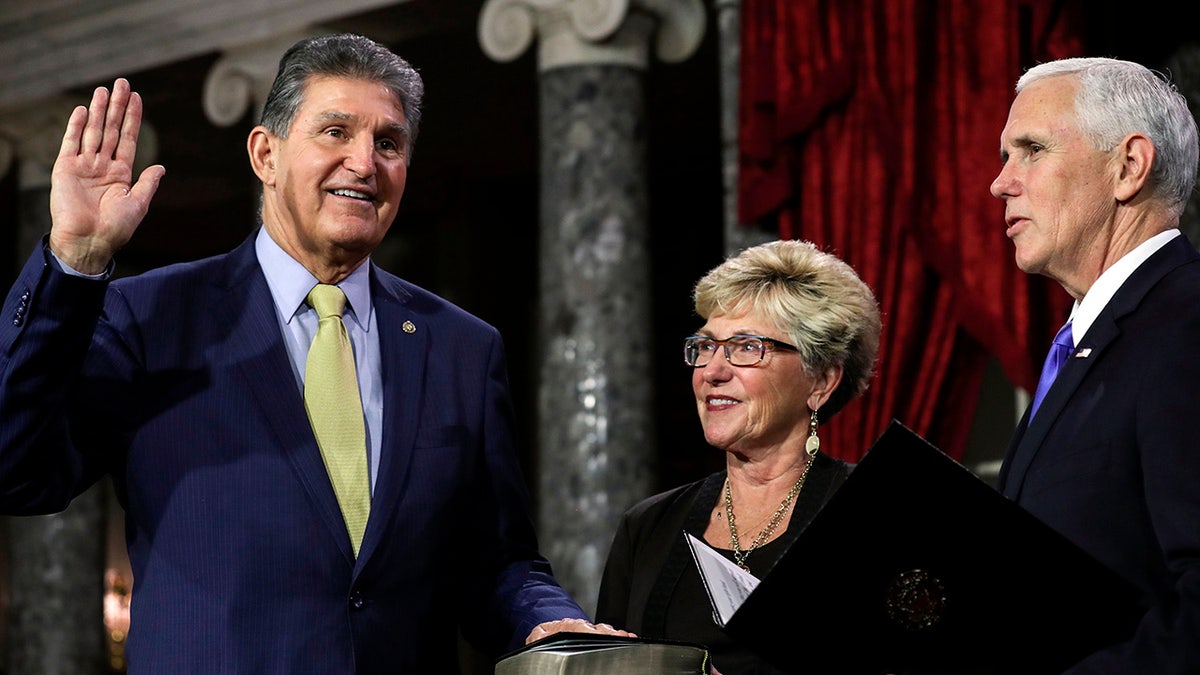 US Senator from West Virginia (D) Joe Manchin III is flanked his wife Gayle as he is sworn in by Vice President Mike Pence during the swearing-in re-enactments for recently elected senators in the Old Senate Chamber on Capitol Hill in Washington, DC January 3, 2019. (Photo by Alex EDELMAN / AFP) (Photo credit should read ALEX EDELMAN/AFP via Getty Images)