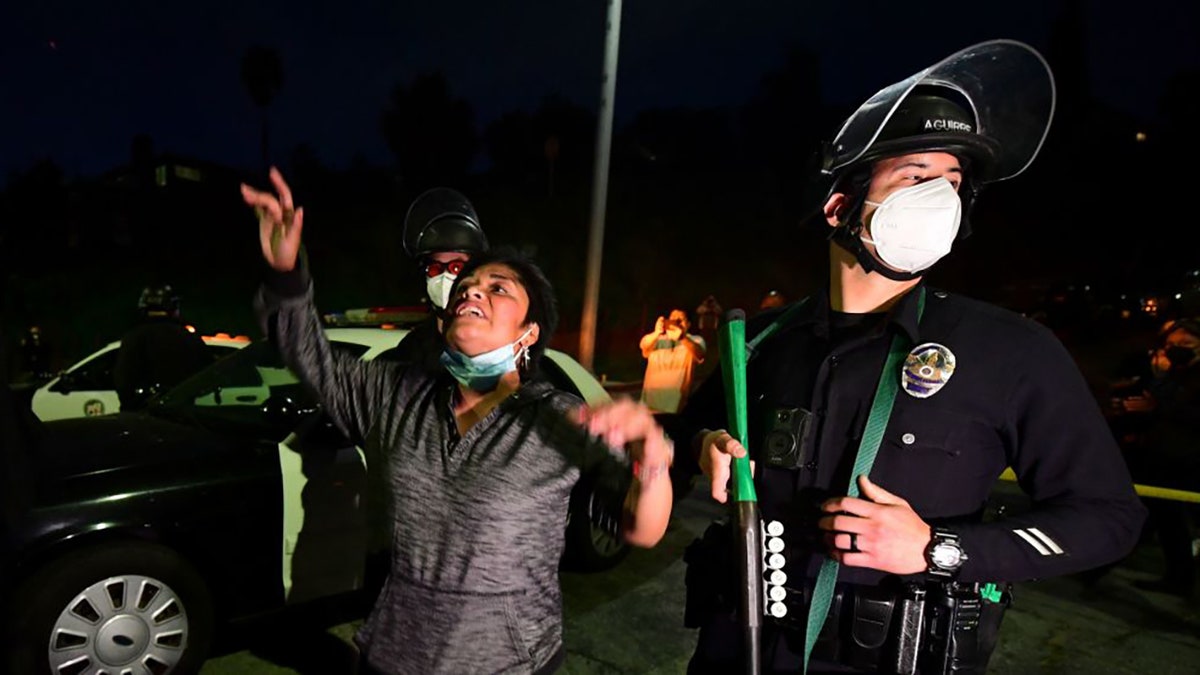 Social activists and supporters of residents of a homeless encampment face police arriving on scene at Echo Park Lake in Los Angeles, March 24, 2021, ahead of a planned and announced cleanup of the encampment as part of an estimated half-million-dollar City of Los Angeles cleanup and repair effort. (Photo by Frederic J. BROWN / AFP) (Photo by FREDERIC J. BROWN/AFP via Getty Images)