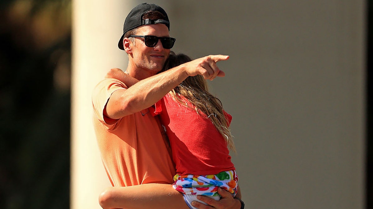 Tom Brady of the Tampa Bay Buccaneers hugs his daughter Vivian celebrating their Super Bowl LV victory during a boat parade through the city on Feb. 10, 2021, in Tampa, Fla. (Mike Ehrmann/Getty Images)