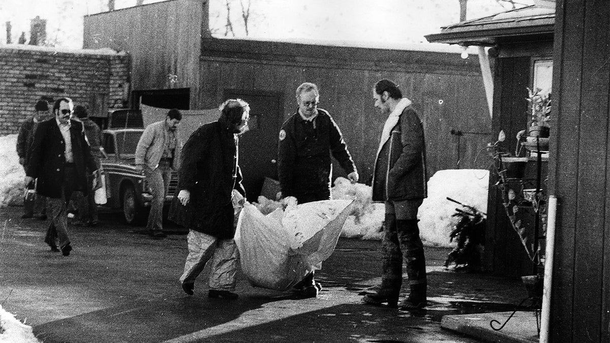 Investigators carry the remains of a body found beneath the garage floor of the home of John Wayne Gacy on December 22, 1978, in Chicago.