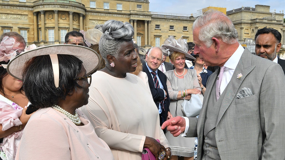 Prince Charles meets Kingdom Choir conductor Karen Gibson, center, and her mother as they attend a Buckingham Palace Garden Party on June 5, 2018, in London. (Getty Images)