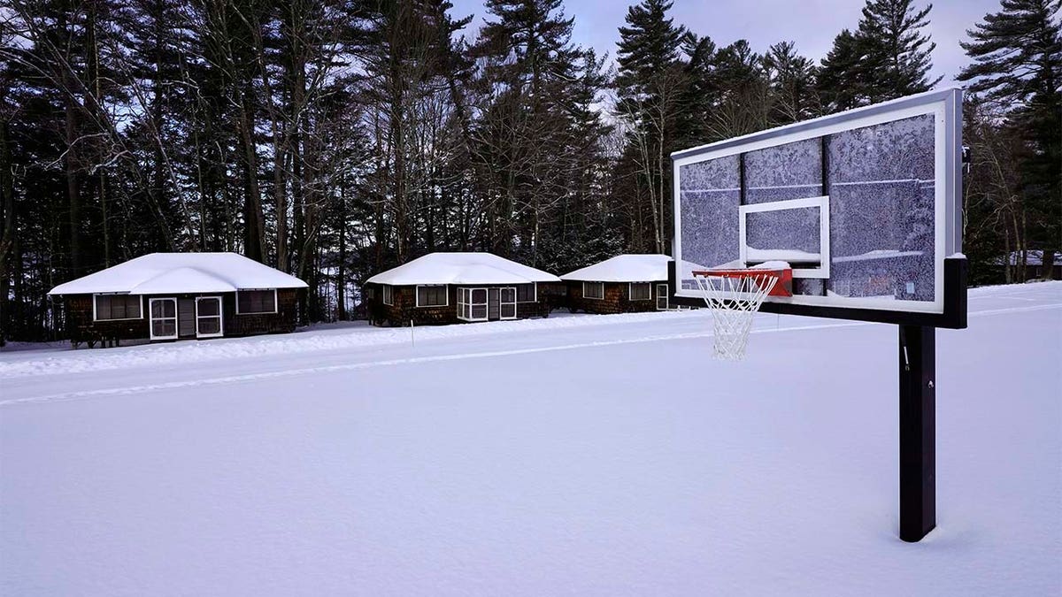 Snow covers a basketball court at Camp Fernwood, a summer camp for girls, Saturday, Feb. 20, 2021, in Poland, Maine.? (AP Photo/Robert F. Bukaty)