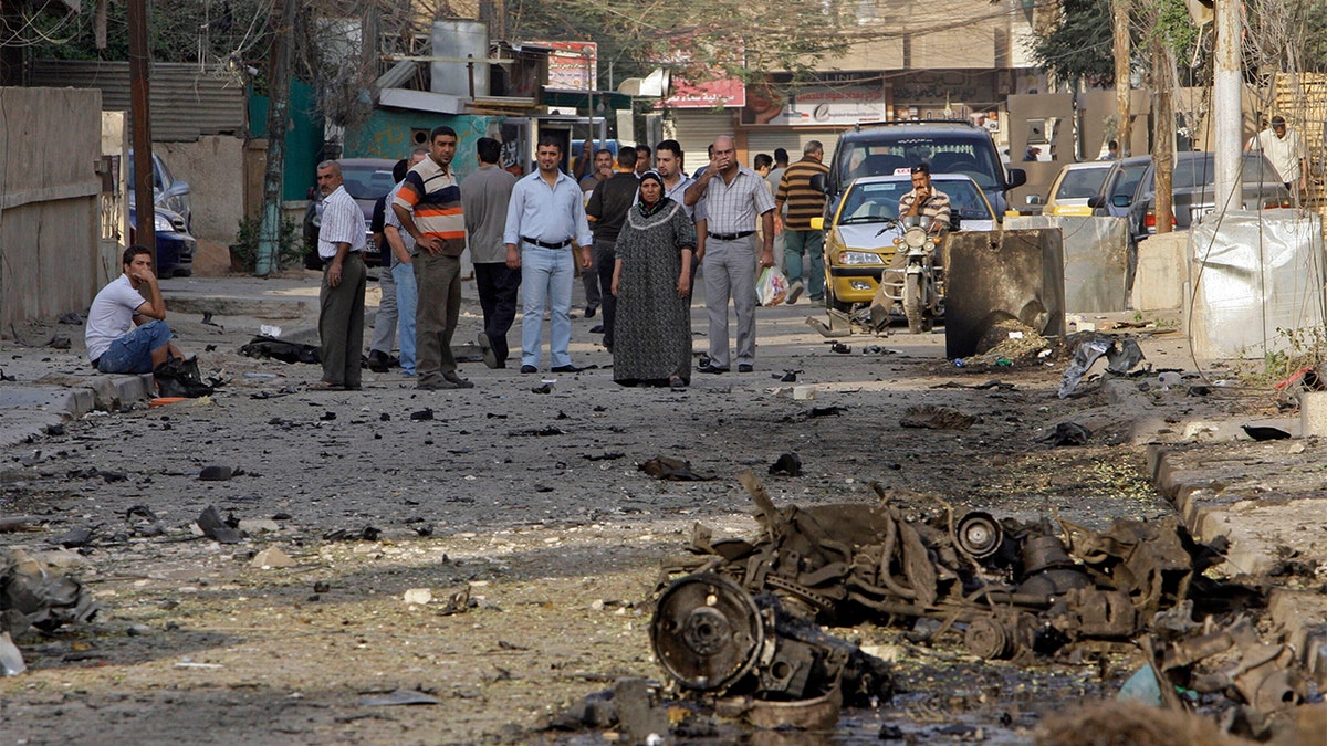 File - In this Monday Nov. 1, 2010 file photo, Iraqis inspect the scene of a car bomb attack in front of a Our Lady of Salvation Church in Baghdad, in Baghdad, Iraq. (AP Photo/Khalid Mohammed, File)