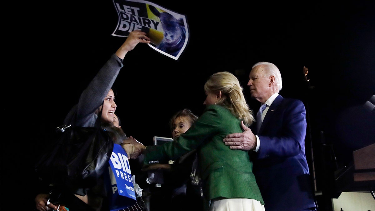 A protester at left, is held back by Jill Biden, center, and her husband, Democratic presidential candidate former Vice President Joe Biden, right, during a primary election night rally Tuesday, March 3, 2020, in Los Angeles. (AP Photo/Marcio Jose Sanchez)