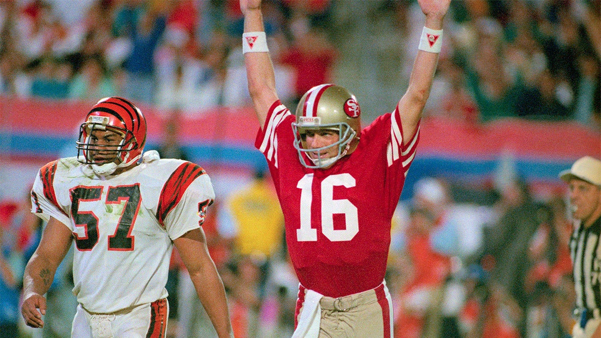 49ers quarterback Joe Montana raises his arms in celebration after throwing a touchdown pass to Jerry Rice.