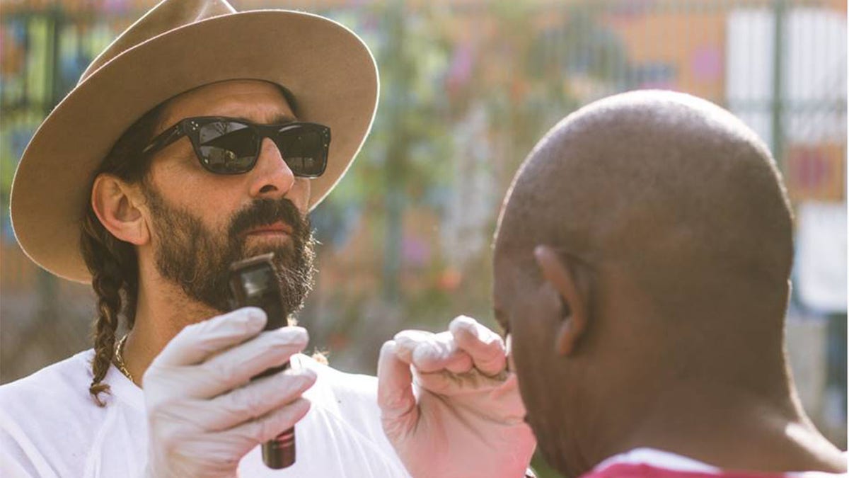 Celebrity men's groomer Jason Schneidman giving haircuts on the streets of Venice, California.