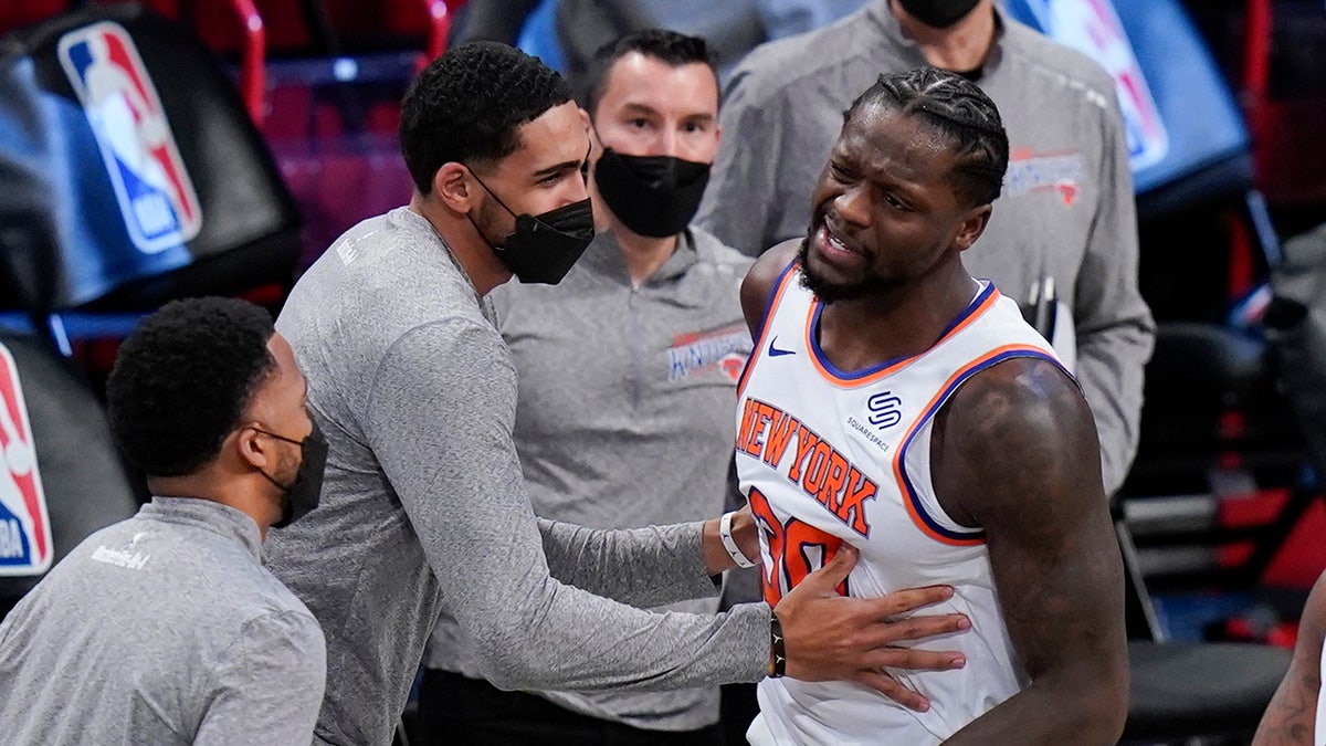 New York Knicks' Julius Randle (30) is restrained by teammates after an NBA basketball game against the Brooklyn Nets, Monday, March 15, 2021, in New York.