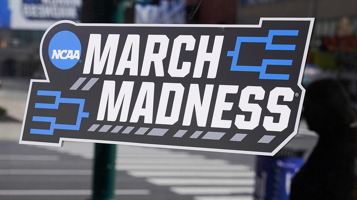 A March Madness sticker for the NCAA college basketball tournament is placed on a window in downtown Indianapolis, Wednesday, March 17, 2021. (AP Photo/Darron Cummings)