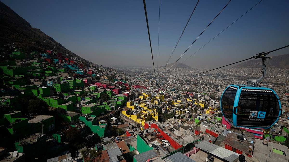 Officials and journalists ride in cable cars between the Campos Revolucion and Tlalpexco stations, during the inauguration of a new aerial public transit system dubbed the Cablebus, in the Cuautepec neighborhood of northern Mexico City.