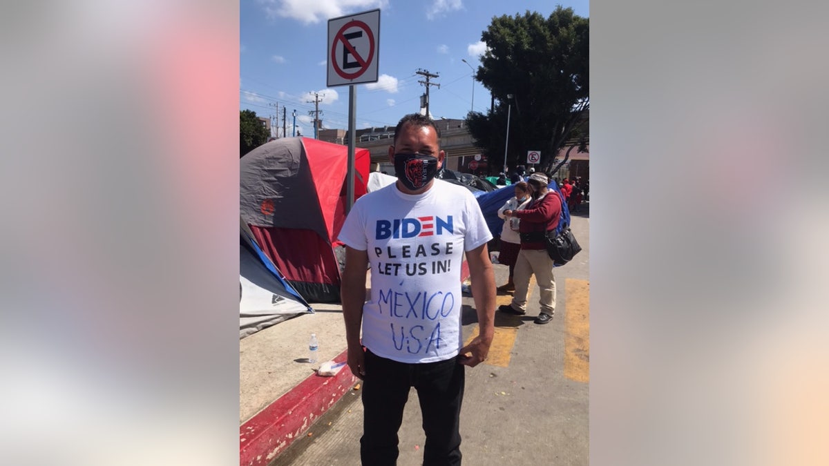 A migrant wears a shirt that reads, "Biden please let us in." Some migrants have said they decided to come to the United States now because Biden won the presidential election. (Griff Jenkins/Fox News)
