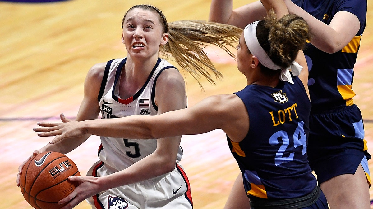 Connecticut's Paige Bueckers drives to the basket as Marquette's Selena Lott, right, defends, during the first half of an NCAA college basketball game in the Big East tournament finals at Mohegan Sun Arena, Monday, March 8, 2021, in Uncasville, Conn. (AP Photo/Jessica Hill)