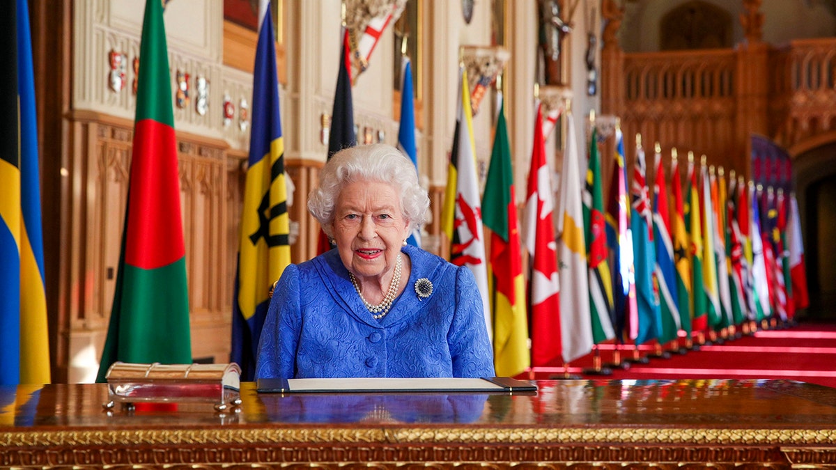 In this photo made available Sunday March 7, 2021, Britain's Queen Elizabeth II poses for a photo while signing her annual Commonwealth Day Message inside St George's Hall at Windsor Castle, England, Friday March 5, 2021.