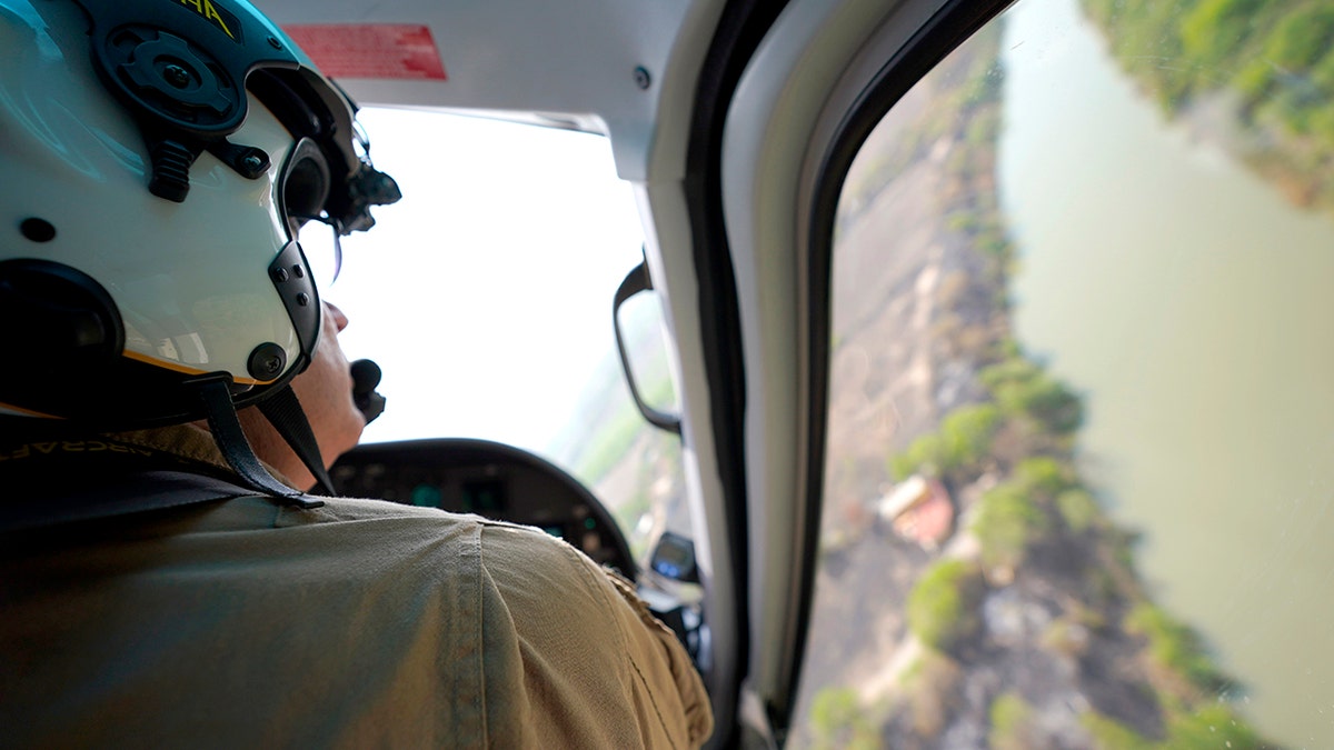 A Texas Department of Public Safety helicopter pilot flies over the Rio Bravo, the U.S.-Mexico border in Mission, Texas, Tuesday, March 23, 2021. 