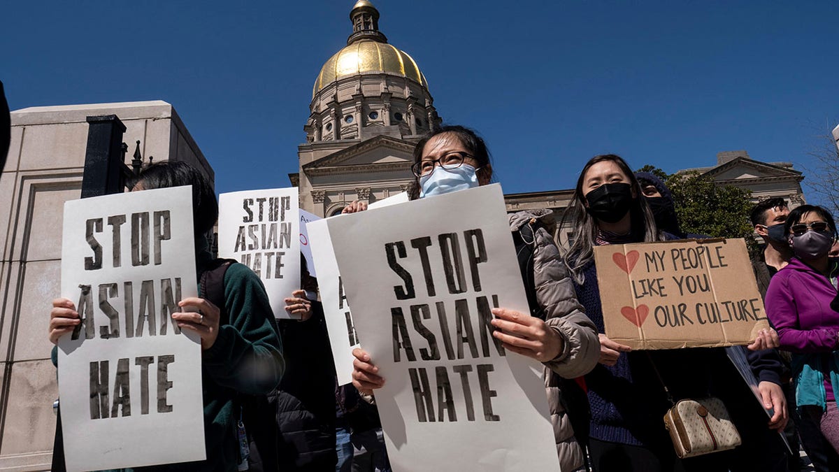 People hold signs while participating in a "stop Asian hate" rally outside the Georgia State Capitol in Atlanta on Saturday afternoon, March 20, 2021. (AP Photo/Ben Gray)
