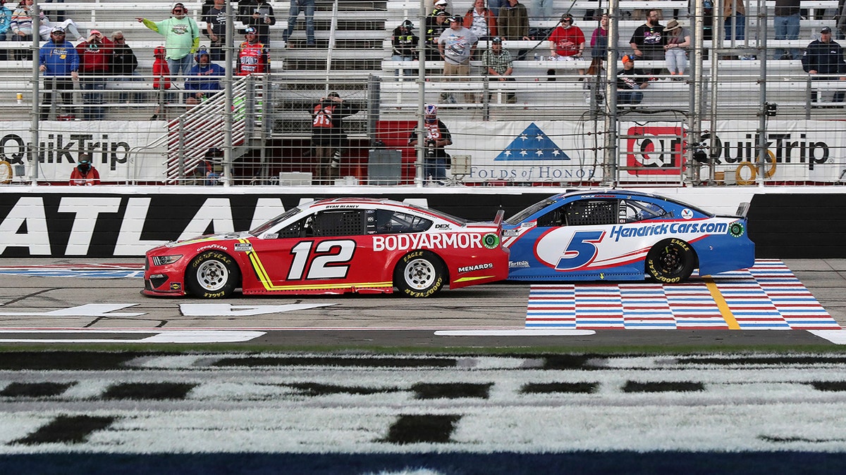 Blaney (12) and Larson (5) cross the start/finish line with eight laps left at Atlanta.