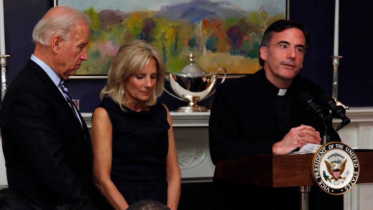 In this Nov. 22, 2010, file photo, Vice President Joe Biden, left, and his wife, Jill Biden, center, stand with heads bowed as the Rev. Kevin O'Brien says the blessing during a Thanksgiving meal for Wounded Warriors in Washington. (AP Photo/Carolyn Kaster, File)