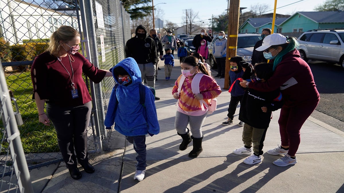 Assistant Principal Janette Van Gelderen, left, welcomes students at Newhall Elementary in Santa Clarita, Calif., on Feb. 25. California's public schools could get $6.6 billion from the state Legislature if they return to in-person instruction by the end of March, according to a new agreement announced Monday, between Gov. Gavin Newsom and the state's legislative leaders. (AP)