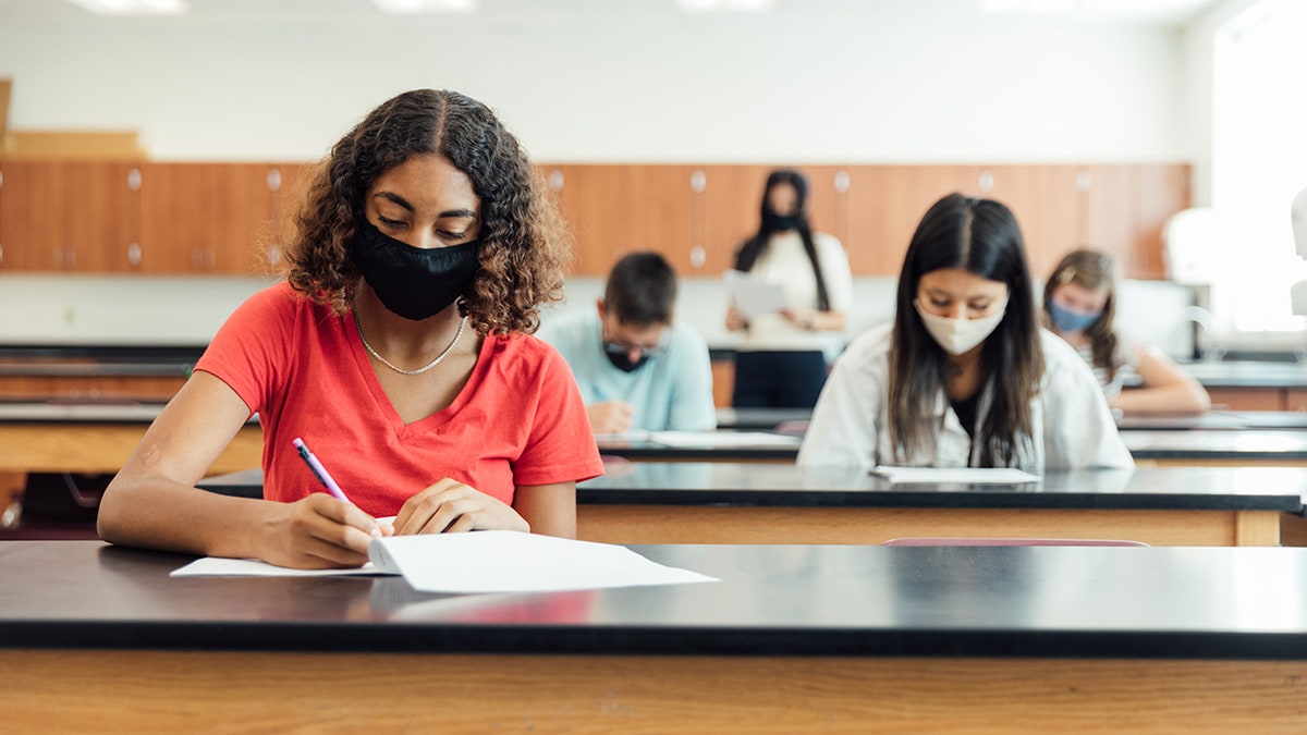 High school students and teenagers go back to school in the classroom at their high school. They are required to wear face masks and practice social distancing during the COVID-19 pandemic. They value their education and are excited to be in school. Image taken in Utah, USA.