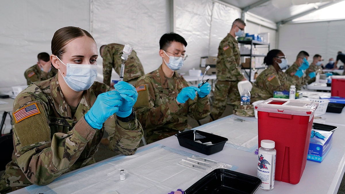 In this March 9, 2021, file photo, Army health specialists fill syringes with the Pfizer COVID-19 vaccine in Miami.
