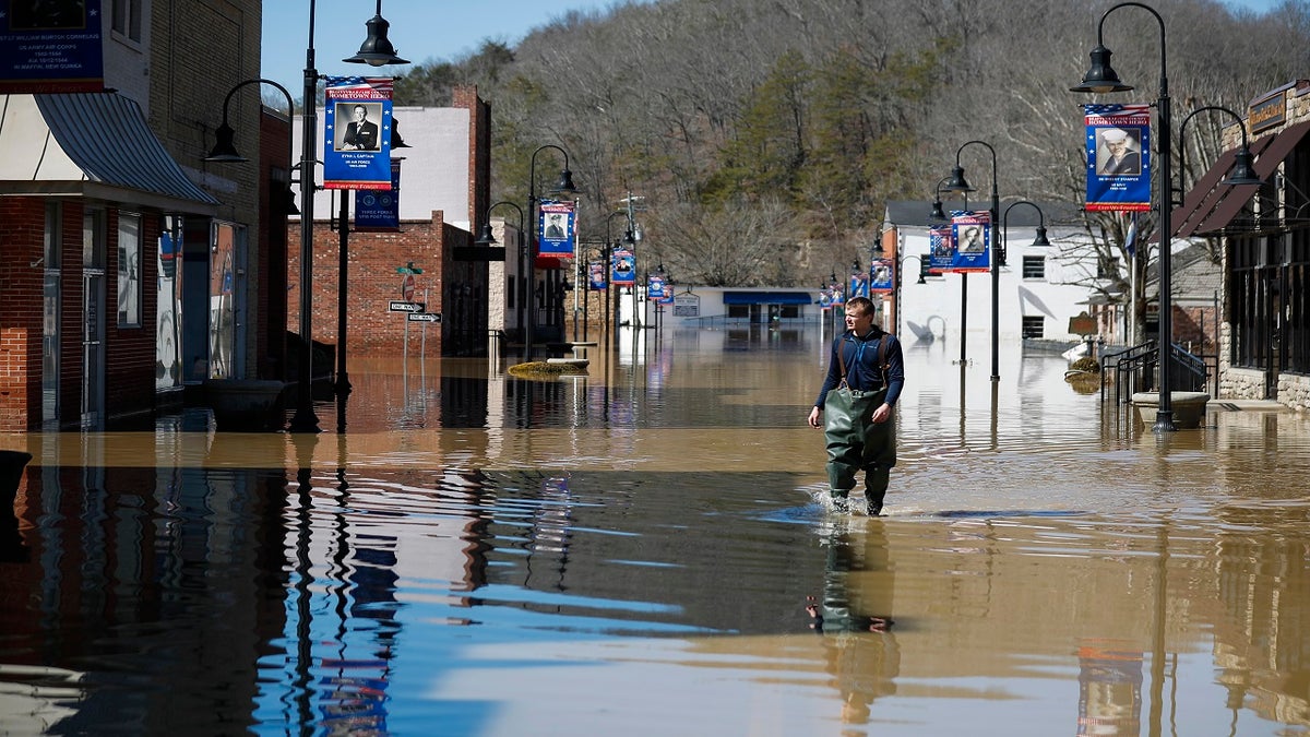 Brad Newnam crosses a flooded East Main Street while checking on businesses in the area in downtown Beattyville, Ky., on Tuesday. Heavy rains caused the Kentucky River to flood most of downtown Beattyville. (AP/Lexington Herald-Leader)