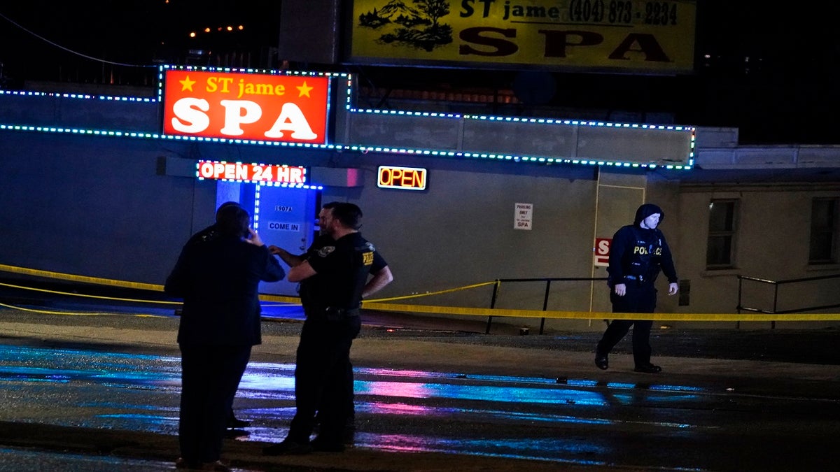 Law enforcement officials confer outside a massage parlor following a shooting on Tuesday in Atlanta. (AP)