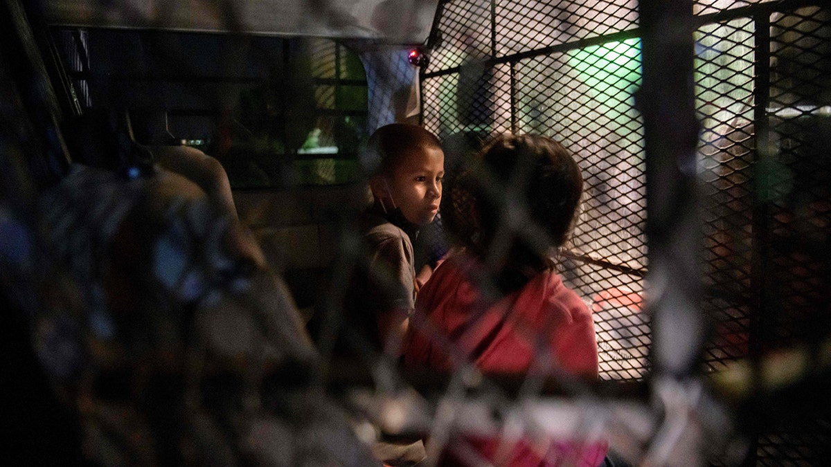 In a photo taken on March 27, 2021 two unaccompanied seven year-old child immigrants who arrived illegally across the Rio Grande river from Mexico stand at a makeshift processing checkpoint before being detained at a holding facility by border patrol agents in the border city of Roma. (Photo by Ed JONES / AFP) (Photo by ED JONES/AFP via Getty Images)